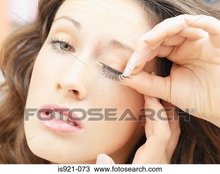 Woman putting on false eyelashes View Large Photo Image Stock Image - Woman putting on false eyelashes. Fotosearch