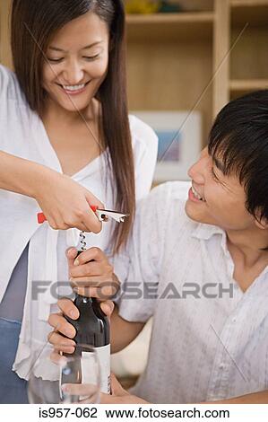 Couple opening wine bottle View Large Photo Image Stock Image - Couple opening wine bottle. Fotosearch
