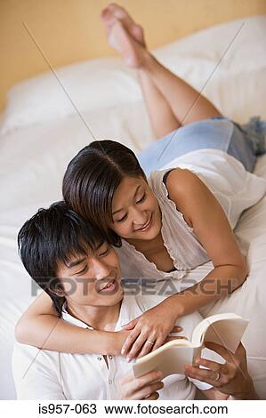 Couple relaxing on bed View Large Photo Image Stock Image - Couple relaxing on bed. Fotosearch