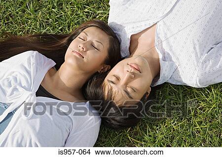 Couple relaxing on grass View Large Photo Image Picture - Couple relaxing on grass. Fotosearch