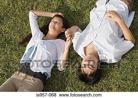 Stock Photo - Couple relaxing on grass. Fotosearch