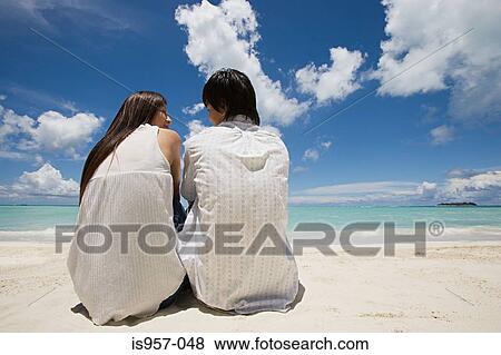 Couple sitting on beach View Large Photo Image Stock Photo - Couple sitting on beach. Fotosearch