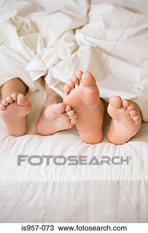 Feet of couple in bed View Large Photo Image Stock Image - Feet of couple in bed . Fotosearch