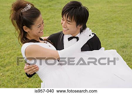 Groom carrying bride View Large Photo Image Stock Image - Groom carrying bride. Fotosearch