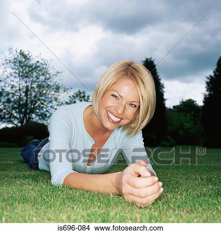 Blond woman lying on grass View Large Photo Image Picture - Blond woman lying on grass. Fotosearch