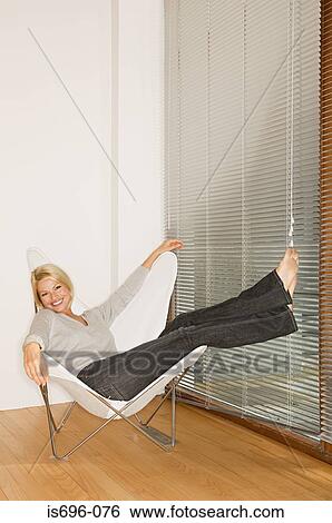 Woman reclining in chair View Large Photo Image Stock Photograph - Woman reclining in chair. Fotosearch
