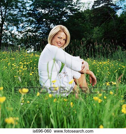 Stock Image - Woman sitting in field. Fotosearch