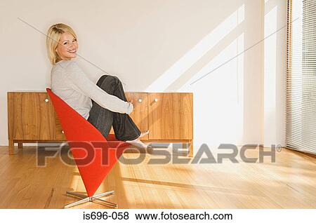 Woman sitting on chair View Large Photo Image Stock Photo - Woman sitting on chair. Fotosearch