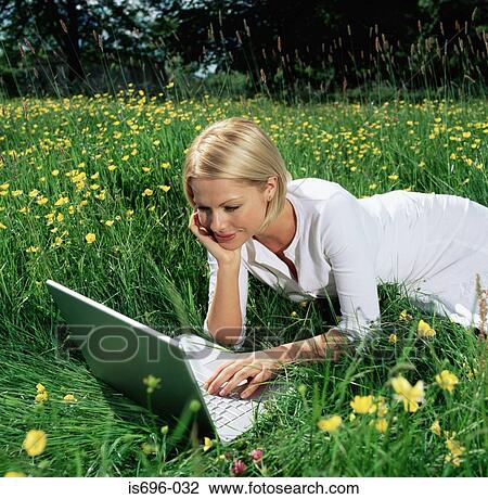 Woman using laptop in field View Large Photo Image Stock Image - Woman using laptop in field. Fotosearch