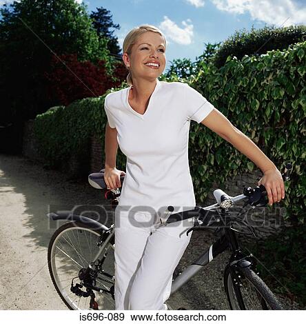 Stock Photo - Woman with bicycle on path. Fotosearch