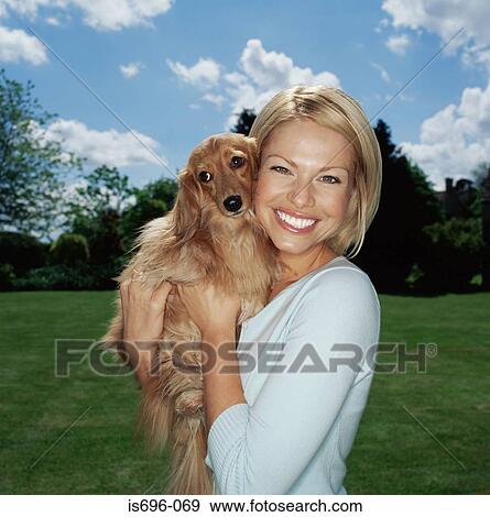 Young woman holding pet dog View Large Photo Image Stock Photo - Young woman holding pet dog. Fotosearch
