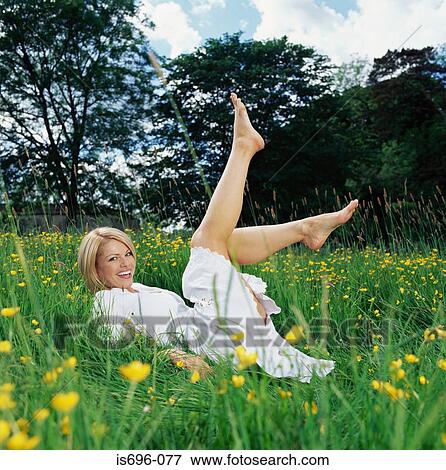 Young woman reclining in field View Large Photo Image Stock Photo - Young woman reclining in field. Fotosearch