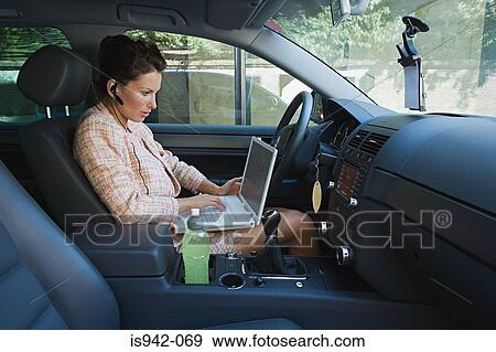Stock Photo - Businesswoman working in car. Fotosearch
