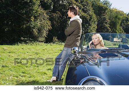 Couple in field with convertible View Large Photo Image Stock Photography - Couple in field with convertible. Fotosearch