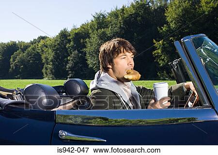 Man driving and having breakfast View Large Photo Image Stock Photo - Man driving and having breakfast. Fotosearch