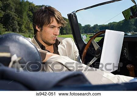 Man in convertible using laptop View Large Photo Image Stock Image - Man in convertible using laptop. Fotosearch