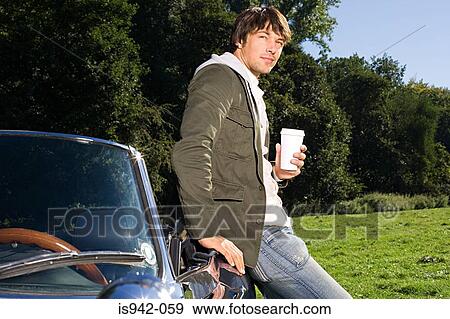 Man in field with coffee and convertible View Large Photo Image Stock Photo - Man in field with coffee and convertible. Fotosearch