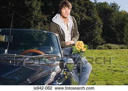 Man with a convertible and bunch of flowers View Large Photo Image Stock Image - Man with a convertible and bunch of flowers. Fotosearch