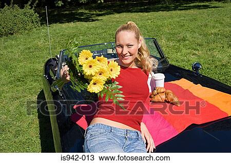Woman on bonnet of convertible with flowers View Large Photo Image Stock Image - Woman on bonnet of convertible with flowers. Fotosearch
