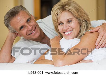 Couple relaxing on bed View Large Photo Image Stock Image - Couple relaxing on bed. Fotosearch