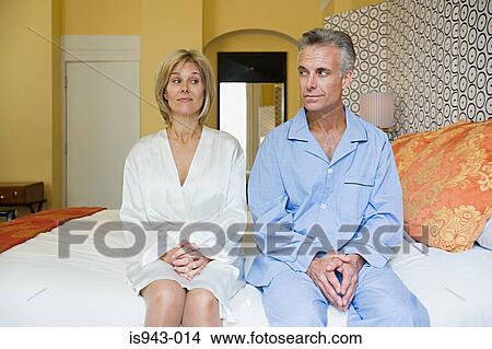 Couple sitting on bed View Large Photo Image Picture - Couple sitting on bed. Fotosearch