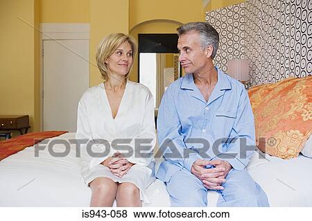 Couple sitting on bed View Large Photo Image Stock Photo - Couple sitting on bed. Fotosearch