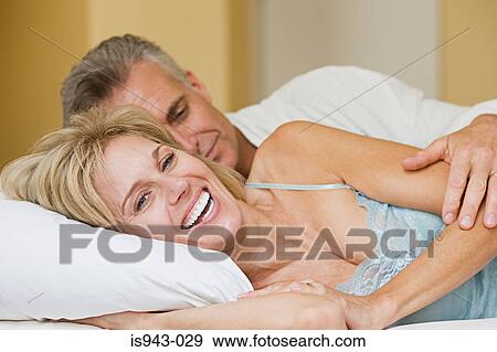 Happy couple lying on bed View Large Photo Image Stock Photo - Happy couple lying on bed. Fotosearch