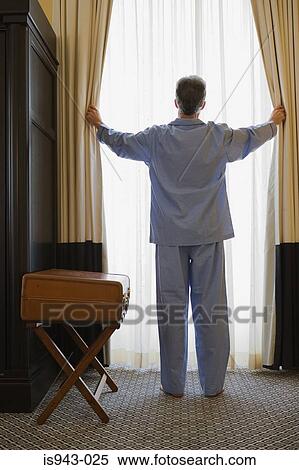 Man opening curtains View Large Photo Image Stock Photography - Man opening curtains. Fotosearch