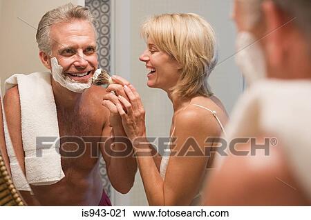 Stock Image - Woman helping husband shave. Fotosearch