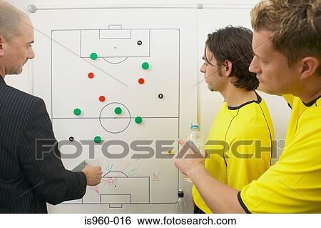 Coach and soccer players discuss strategy View Large Photo Image Stock Photograph - Coach and soccer players discuss strategy. Fotosearch