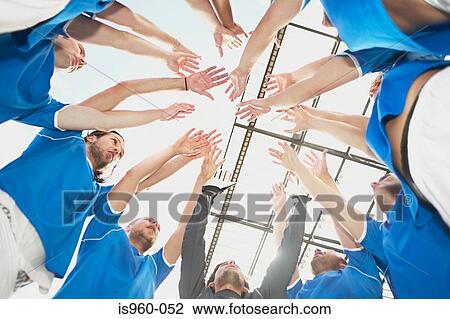 Stock Image - Football team raising their arms. Fotosearch