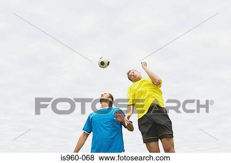 Stock Photo - Footballers heading the ball. Fotosearch