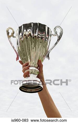 Holding up the cup View Large Photo Image Stock Image - Holding up the cup. Fotosearch