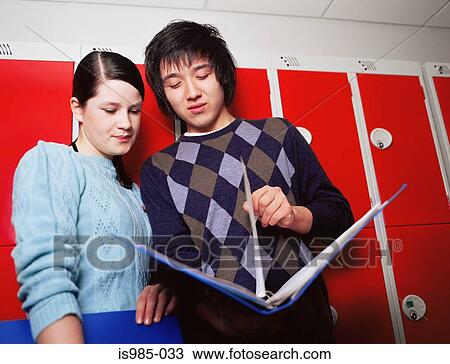 Boy and girl looking at folder View Large Photo Image Stock Image - Boy and girl looking at folder. Fotosearch