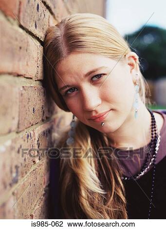 Stock Image - Girl leaning against a wall. Fotosearch