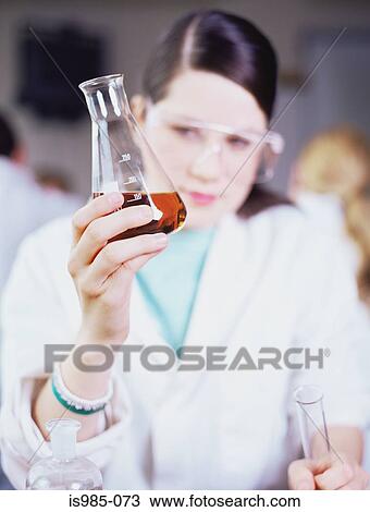 Girl looking at chemical in flask View Large Photo Image Stock Image - Girl looking at chemical in flask. Fotosearch