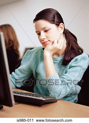 Stock Image - Girl sitting at computer. Fotosearch