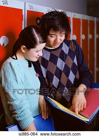 Picture - Students looking at folder. Fotosearch