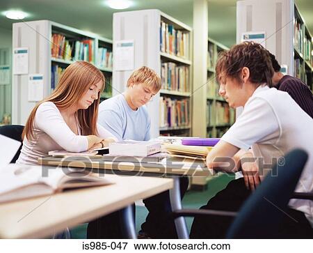 Stock Photo - Teenagers studying in the library. Fotosearch