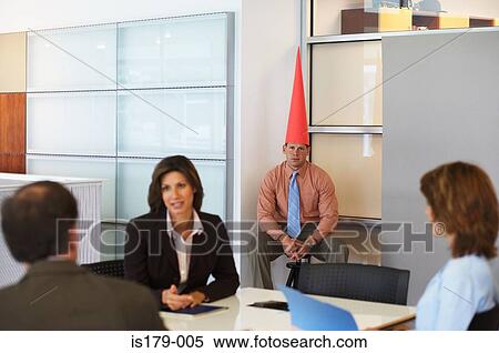 Stock Photography - Business meeting with dunce sat in corner. Fotosearch