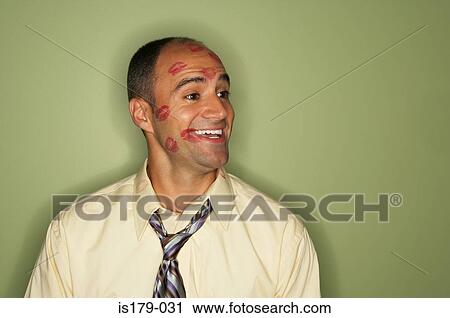 Stock Image - Businessman covered in lipstick kisses. Fotosearch