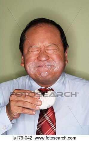 Businessman eating a doughnut View Large Photo Image Stock Image - Businessman eating a doughnut. Fotosearch