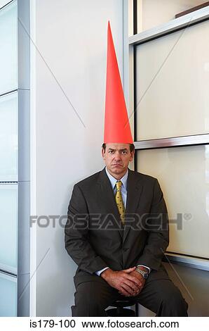 Stock Image - Businessman wearing dunce cap. Fotosearch