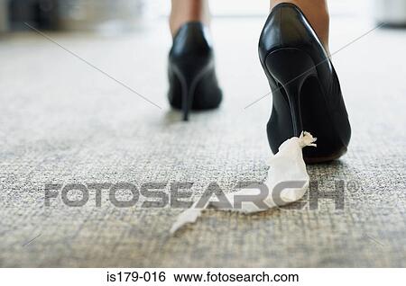 Stock Photograph - Businesswoman with toilet paper stuck to her shoe. Fotosearch