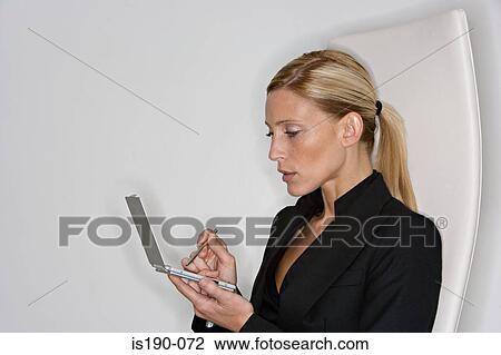 Stock Image - Businesswoman using handheld computer. Fotosearch
