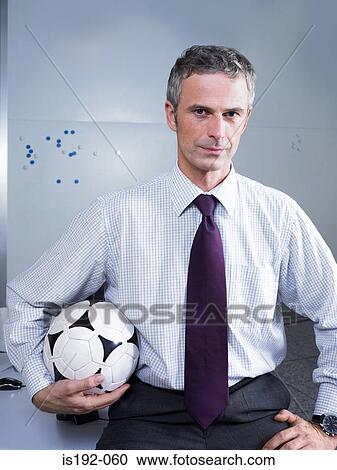 Businessman holding a football View Large Photo Image Stock Image - Businessman holding a football. Fotosearch