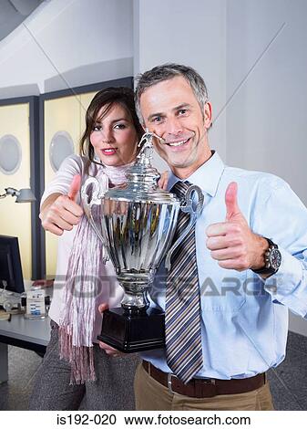 Stock Image - Colleagues with trophy. Fotosearch