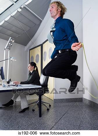 Man skipping in office View Large Photo Image Stock Photograph - Man skipping in office. Fotosearch
