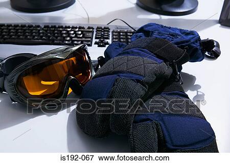 Stock Photo - Ski goggles and gloves on a desk. Fotosearch