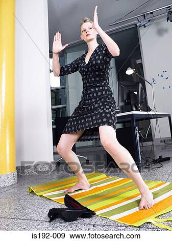 Stock Photo - Woman doing karate in office. Fotosearch